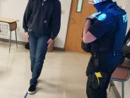 student walking line with an officer observing